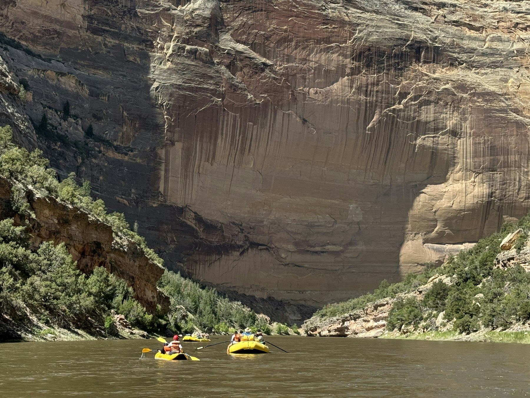 Paredes altas de un cañón con kayaks en el río